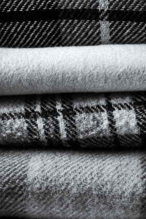 Stack of woolen checked blankets, autumn and winter concept, gray image with trendy color of 2021