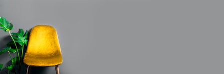 Modern Yellow Velour Chair on wooden legs with monstera plant nearby on gray background, trendy colors of 2021, banner sizeの写真素材