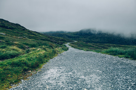 Beautiful landscape panorama of Miners Tack in Snowdonia National Park in North Wales, UK. Shoot during gloomy cloudy day with strong fogの写真素材
