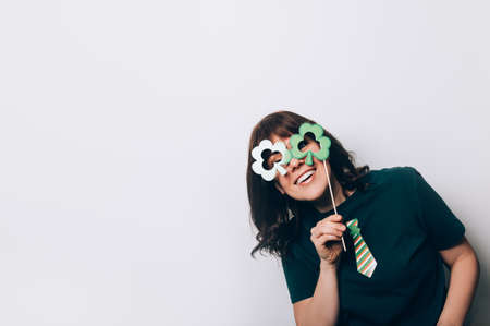 Young woman is preparing for the St Patricks Day party with photo booth props, Ireland traditional...
