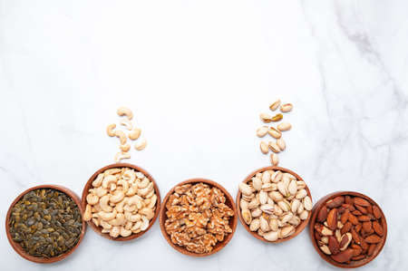 Different kind of nuts in wooden bowls