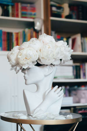 Bunch of white peonies in human head vaseの写真素材