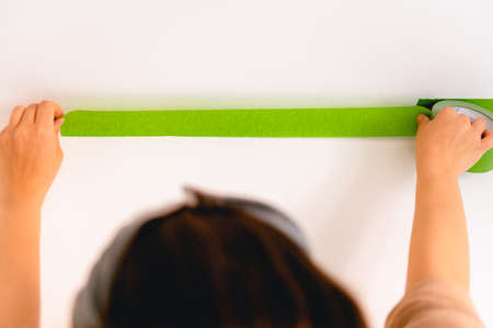 Applaying masking tape to the wall