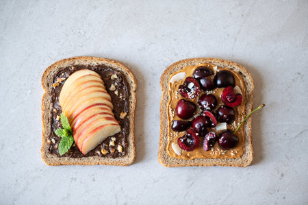 Various kind of open sandwiches with berries and fruits. Made from wholegrain bread and different nut butter, such as peanut butter and crunchy cashew or almond butterの写真素材