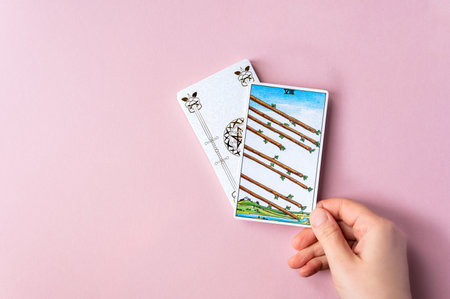 London, UK: 6 January, 2023: Minor Arcana - Eight of Wands of Tarot Card of Rider Waite deck in hand...