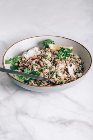 Healthy Salad made from Quinoa, Cucumber, Herbs, Pistachios, Chickpeas and Feta with lemon juice and olive oil. So called Jennifer Aniston Salad, fresh, crunchy, and packed with plant-based proteinの写真素材