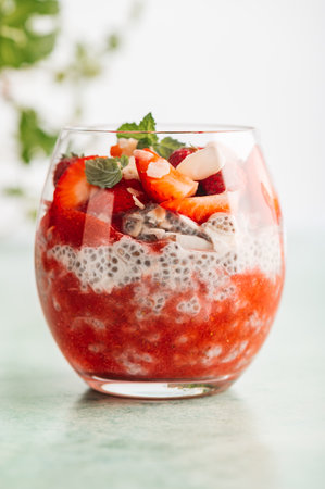Healthy chia pudding in a glass with fresh strawberries made from almond milk and berry juice. Perfect breakfast for healthy start of the dayの写真素材