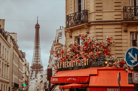 Paris, France - March 30, 2024: Parisian street and cafe with flowers on terrace during early spring...