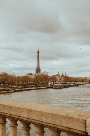 Paris, France - March 30, 2024: The Pont Alexandre III arch bridge,the Seine, river taxis and Eiffel...