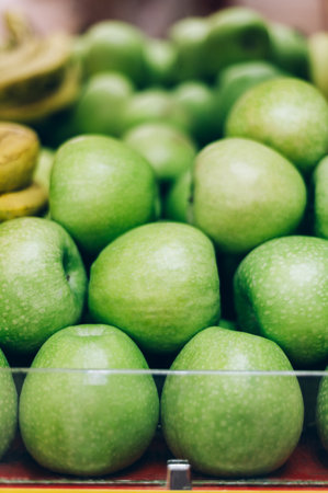 A lot of fresh organic green apples on market stall or in groceries shop area. Apple background. Fruit food backgroundの写真素材
