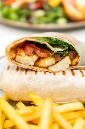 Halloumi wraps with roasted chickpeas, tomatoes and minty yoghurt sauce. These wraps are super tasty, filling and great for lunch or dinner. Served together with french fries and vegetable saladの写真素材