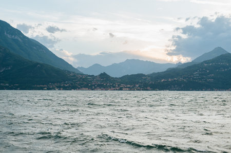 Beautiful Lake Como, Lombardy, Italy shoot from Varenna waterfront on summer afternoon shoot during windy cloudy dayの写真素材