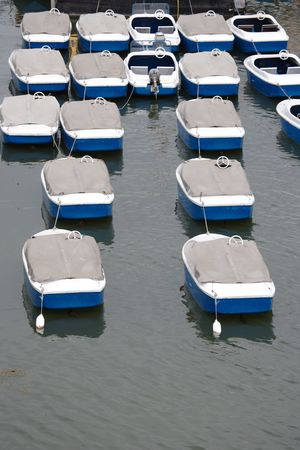recreational boats in a row covered with canvas