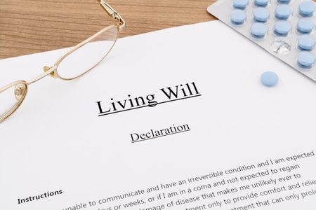 living will with pills and eyeglasses on wooden tableの写真素材
