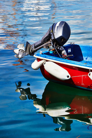 Isles of Scilly, United Kingdom - Detail of an outboard motor on a small boat floating in calm water...