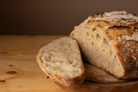 Healthy and very crunchy sourdough bread resting on a board.の写真素材