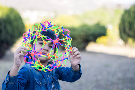 Little girl looking through a colorful toy.