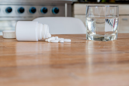 Pills with glass of water on the kitchen table.の写真素材