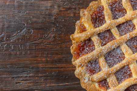 Close-up of a warm homemade Pasta Frola tart filled with quince. Argentinian Pastafrola Recipe on wooden table.の写真素材