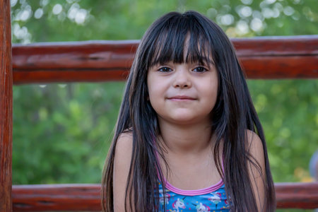 Portrait of a cute Argentinian girl with long hair, who plays in the park.の写真素材