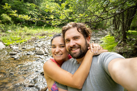 Young Argentinian couple taking a selfie in a natural landscape.の写真素材