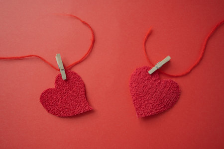 Two hearts that were joined with a red thread that breaks.の写真素材