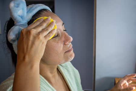Latin woman cleaning her face with facial foam.の写真素材