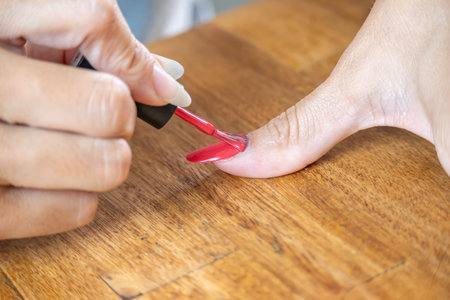 Woman painting her big finger with a semi-permanent nail polish.の写真素材