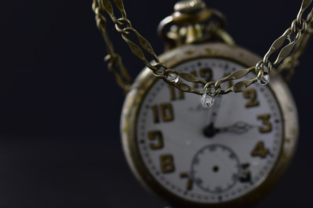 drop of water, reflecting a pocket watch, concept of time melting awayの写真素材