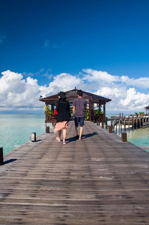 Tourist couples walk on man-made walkway exotic tropical resort of Kapalai islandの写真素材