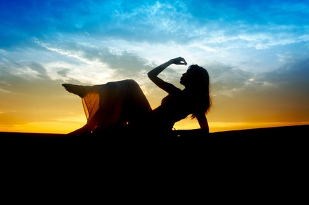 Silhouette of young sensuality beautiful woman during sunsetの写真素材