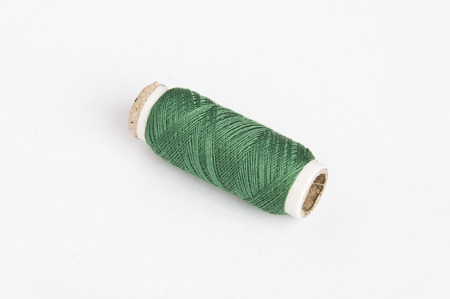 Green thread roll on white background