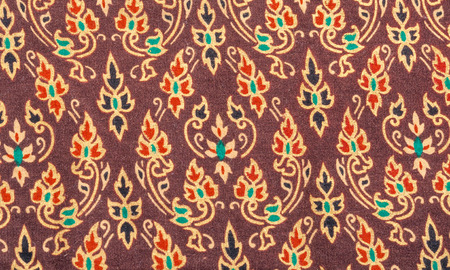 An exotic colorful floral pattern weaved fabric as textural background 