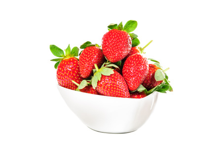 Strawberries with leaves in bowl on a white backgroundの写真素材