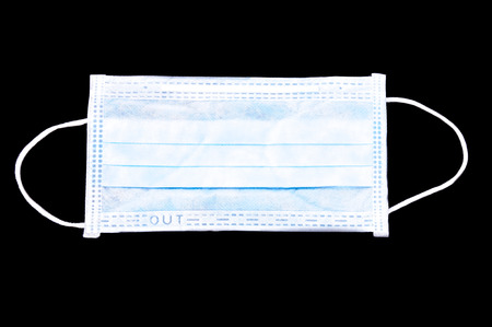 Disposable face mask (with clipping path) isolated on dark background