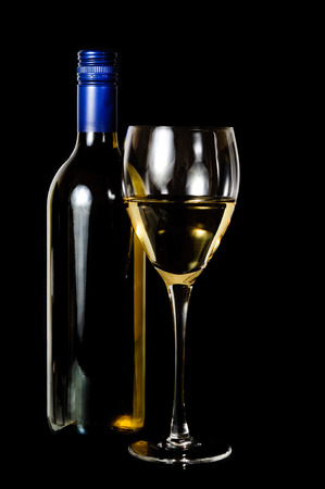 A glass and blue rit  bottle of white wine on dark backgroundの写真素材