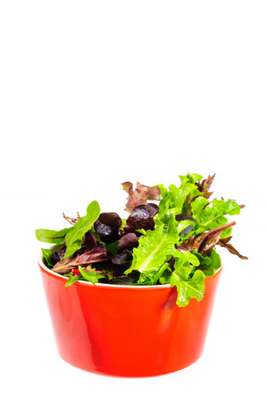 Mix salad in red bowl Isolated on white background.の写真素材
