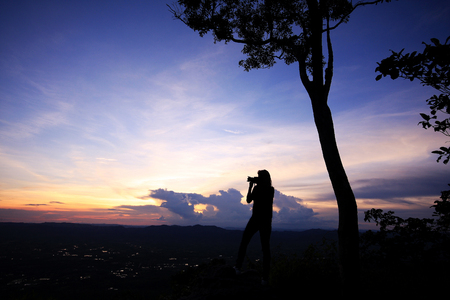 People standing on the mountain in the evening.の写真素材
