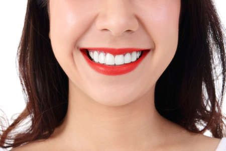 Asian women have beautiful smiles, clean white teeth, red lips, white background. Dental care...