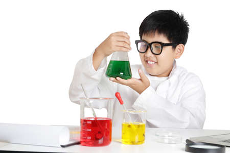 Elementary school boys wear white clothes, doing science experiments in the laboratory. Concept of child education development. isolatedの写真素材
