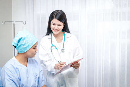 Female doctors recommend patients using chemotherapy as a way to help control cancer. There are questions about the history of patient information and general physical examination. Treatment conceptsの写真素材
