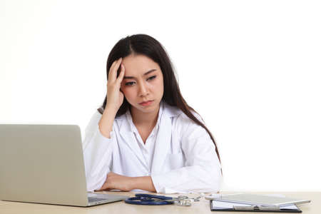 Asian female doctor sitting stressed from hard work Sit at your desk. Concepts of hospital treatment of patients. White background. Coronavirus 2019の写真素材