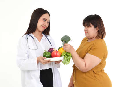 Beautiful doctor, nutritionist, carrying fruits and vegetables Give advice to overweight female...