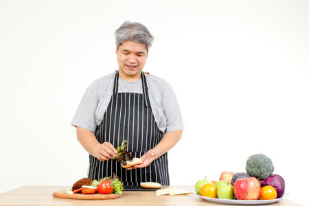 Fat old man Make a hamburger. The concept of healthy eating for the elderly. White background
