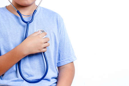 The boy wears a medical stethoscope to listen to the sound of his own heart. Concept of child treatment. White backgroundの写真素材