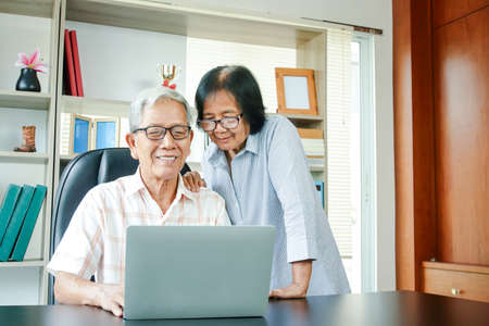 Asian elderly couple work from home, happy in retirement. Health insurance concept, social security,...