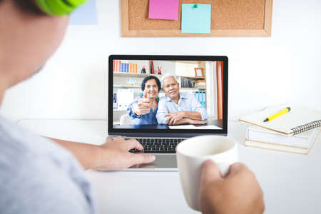 he son talked to his father and mother Asian Elderly Via the video call app on a home notebook computer. Social Distancing concept prevents the spread of the coronavirus.の写真素材