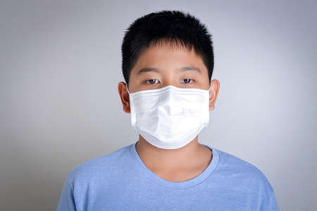 An Asian boy wears a mask, covering his mouth and nose, preventing coronavirus. And dust, pm 2.5. Children's health conceptの写真素材