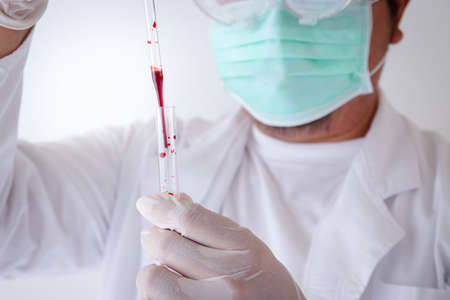 Medical researchers wear masks and latex gloves to prevent germs, do experiments in the laboratory. To find a cure for the coronavirusの写真素材