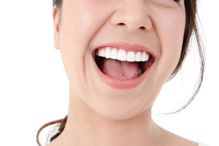 Asian women have beautiful smiles, clean white teeth, pink lips. Healthy skin. Dental care concept, cleanliness. Prevent germs. White backgroundの写真素材